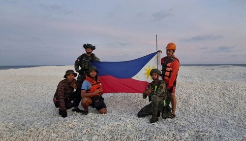 남중국해 암초서 국기 펼친 필리핀 군인들 [서필리핀해 국가 태스크포스 관계자 엑스(X·옛 트위터) 캡처]
